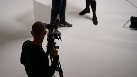 Overhead-Shot-Of-Male-Film-Camera-Operator-Focusing-Camera-Using-Monitor-Shooting-Movie-Or-Video-In-Studio-1